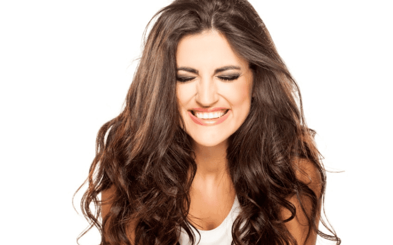 moça sorrindo com cabelos definidos após uso de leave-in