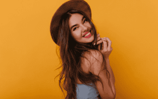 moça com chapeu sorrindo porque sabe como ter um glow up