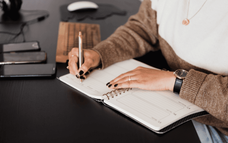 mãos de mulher escrevendo em um caderno